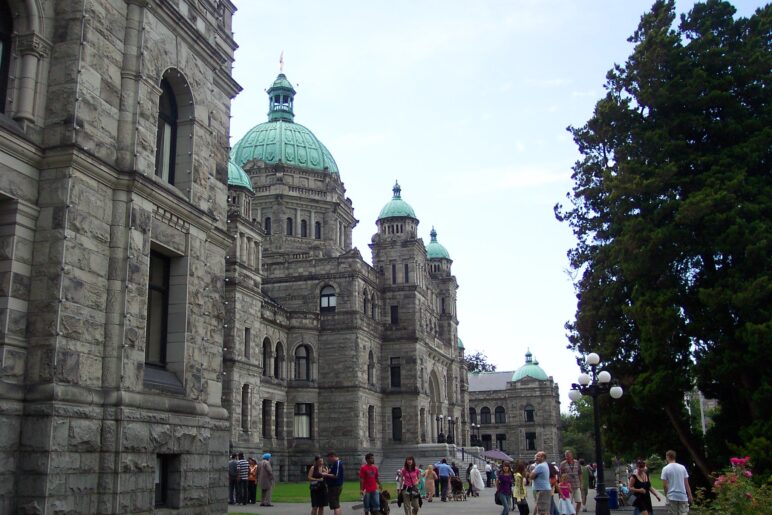 The Legislative Building in Victoria, BC. with visitors mingling on the lawn