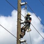 WAPA Rocky Mountain Lineman Dusty Haskins attaches conductor to the insulators on a St. Thomas utility pole, Oct. 5. Part of the deployed 25-member crew, Haskins, aiding U.S. Virgin Islands Water and Power Authority in power restoration of its 34.5-kv transmission system following the system damaged caused by Hurricanes Irma and Maria. (Photo by Kevin Ripplinger)